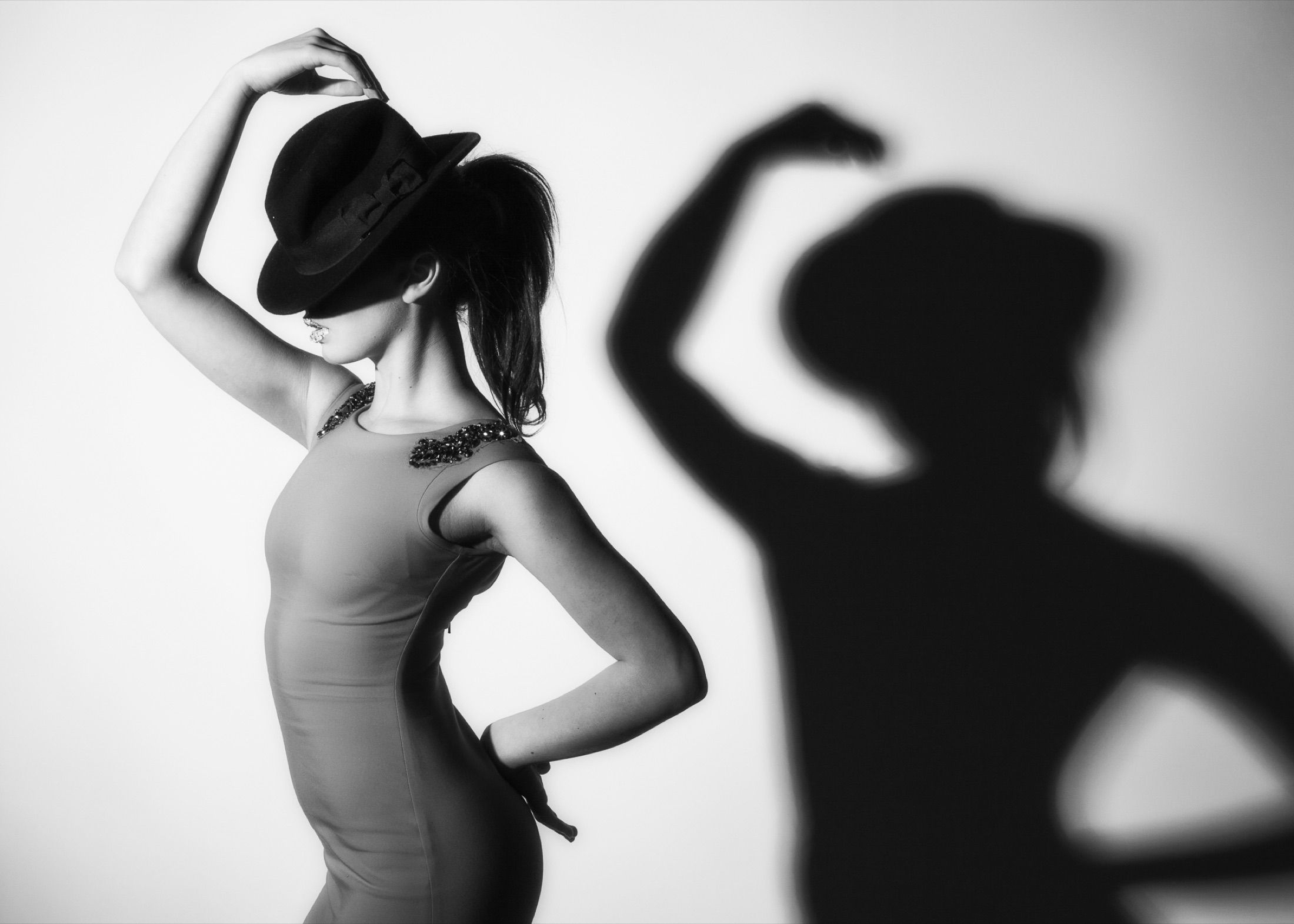 Black and white fashion portrait with graphic hat shadow